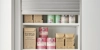 Un placard de cuisine avec étagères ouvertes remplies de nourriture, conçu par Nolte Kitchen.