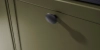 Un placard de cuisine vert avec un bouton noir, partie de Nolte Kitchen.