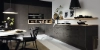 Cuisine moderne avec armoires sombres, table à manger et décorations, conçue par Nolte Kitchen.