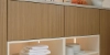 Ein modernes Wohnmöbel mit Geschirr und Deko-Elementen im Regal, präsentiert von Nolte Living.