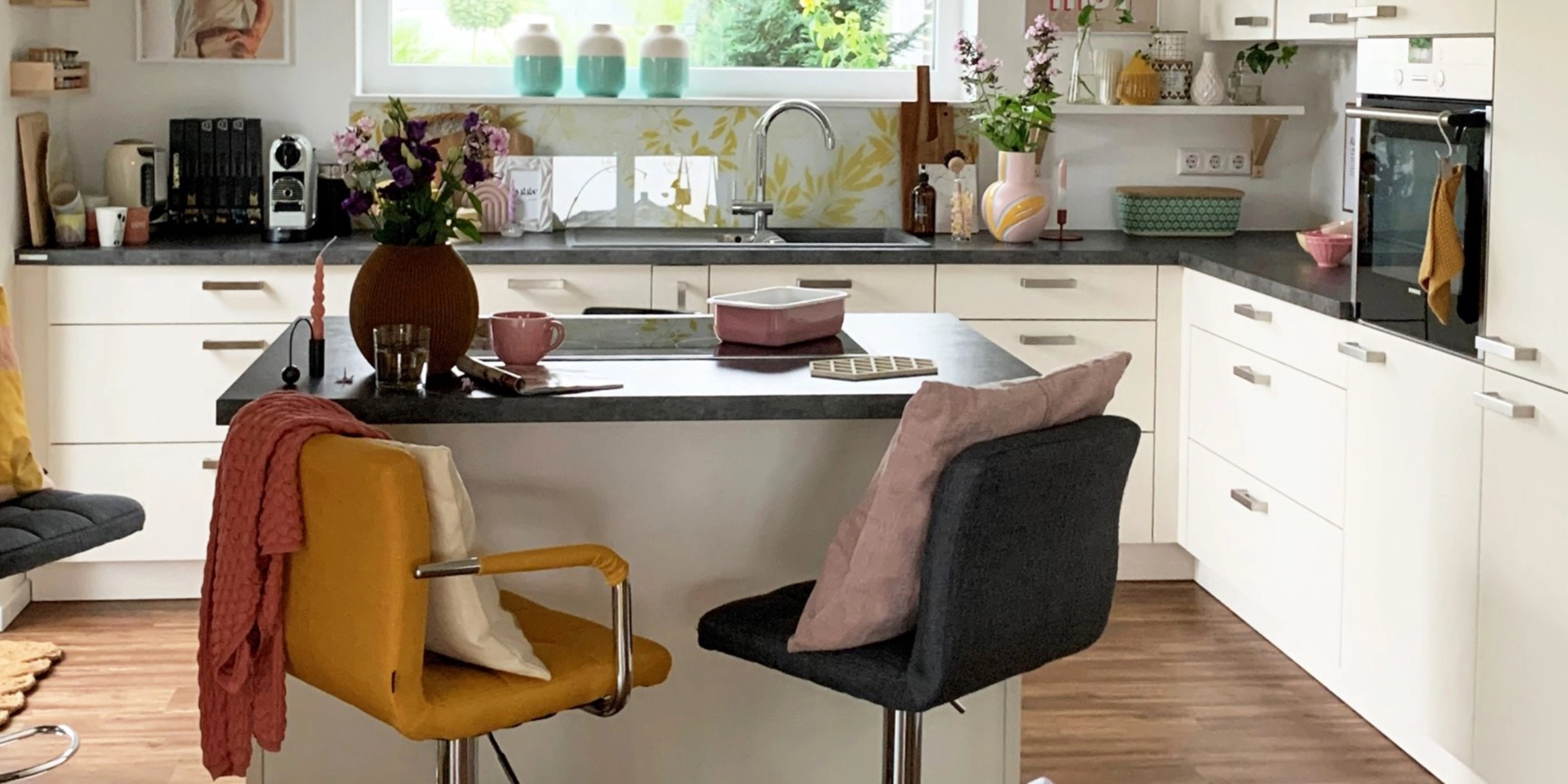 A modern, bright kitchen with an island and colorful accents by Nolte Kitchen.