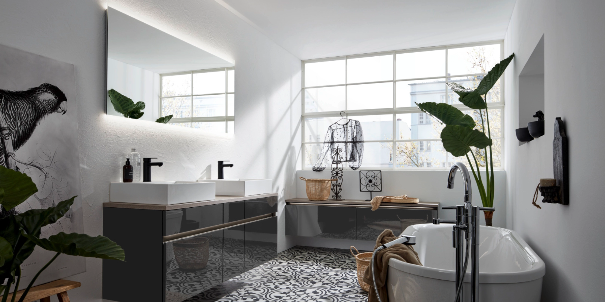 Ein modernes Badezimmer mit Badewanne und Doppelwaschbecken, umgeben von Pflanzen. Nolte SPA.