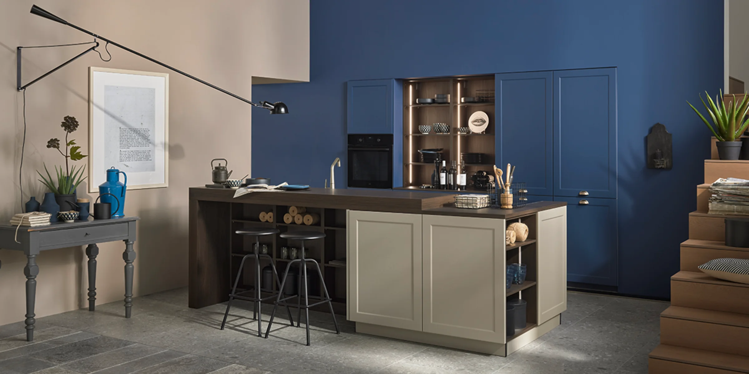 Ton-in-Ton Küche von Nolte Küchen mit blauen Mattlack-Fronten, passender Wandfarbe und Kücheninsel in ruhigen Farbtönen in einem offenen Wohnraum.