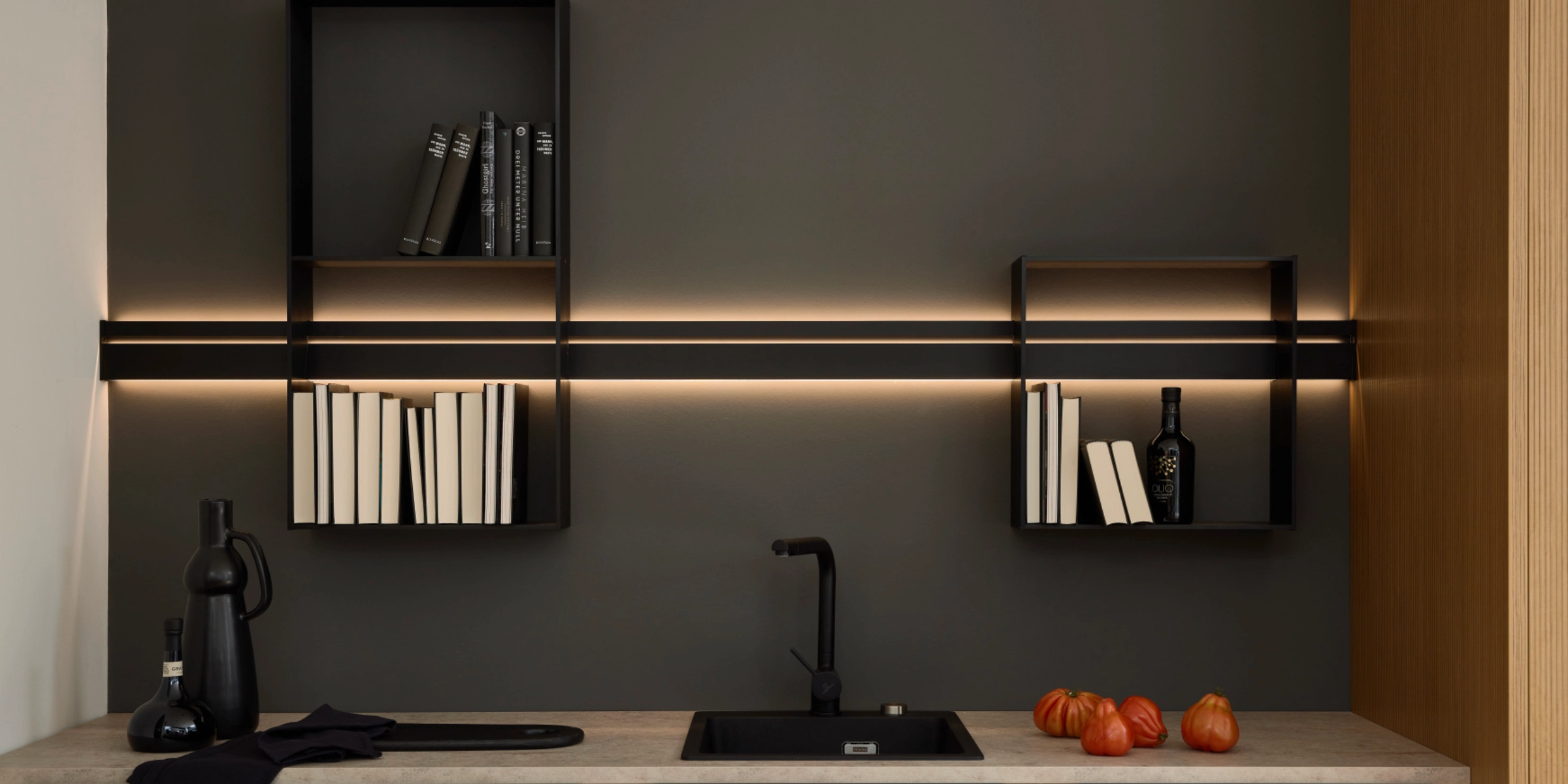 Cuisine moderne avec étagères suspendues sombres et éclairage LED, conçue par Nolte Kitchen.