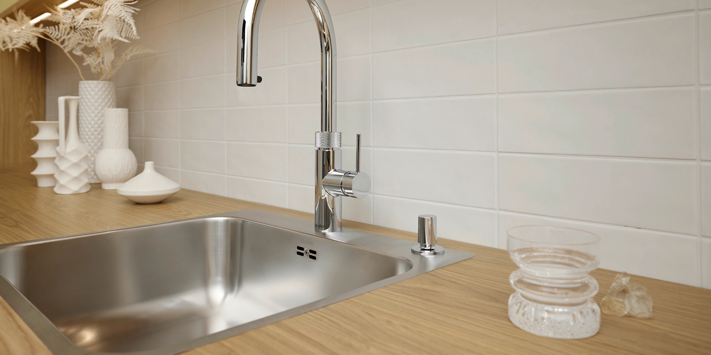 Cuisine moderne avec plan de travail en bois et évier en acier inoxydable de Nolte Kitchen.