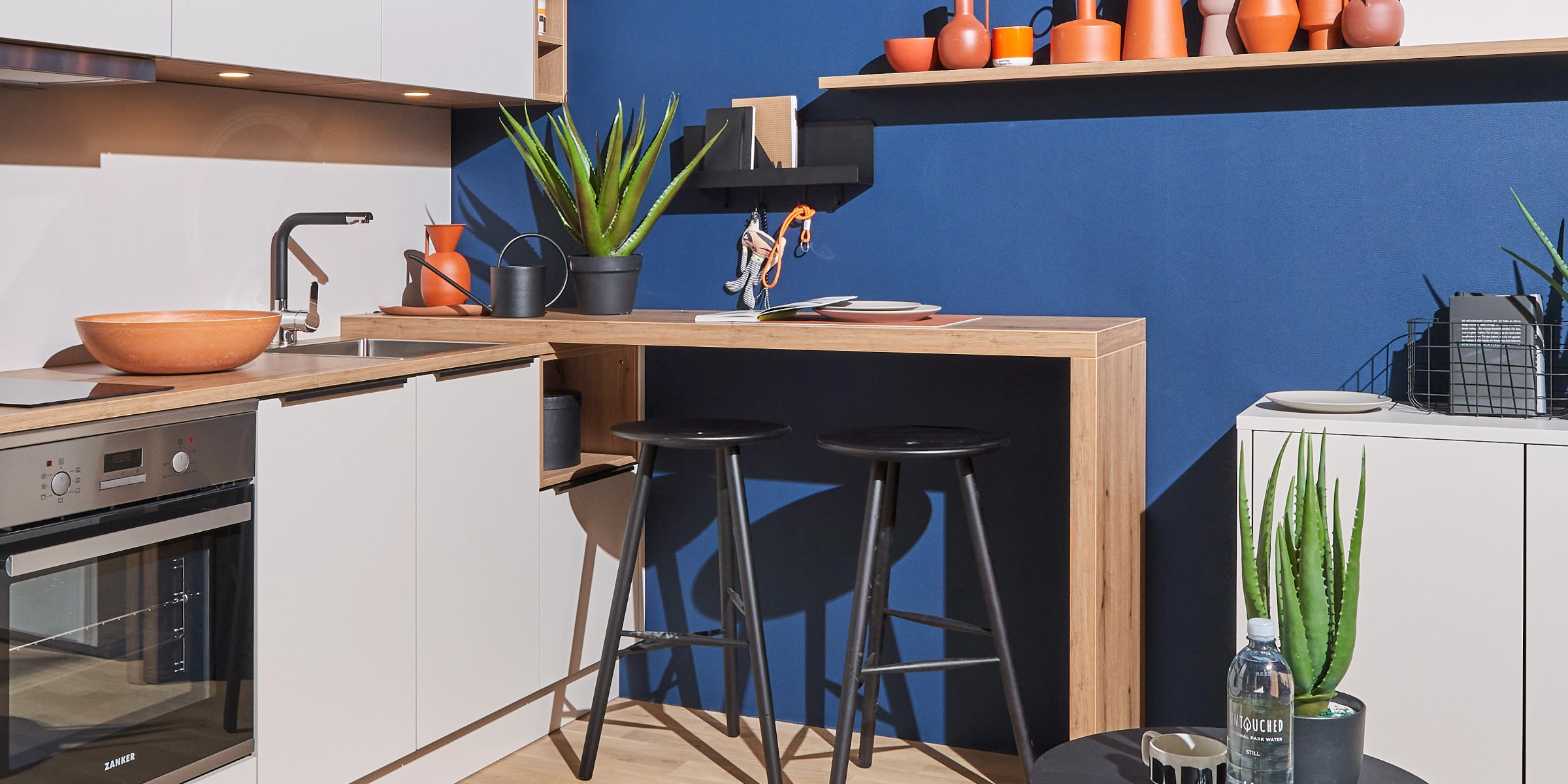 Une cuisine moderne avec murs bleus et plantes, conçue par Nolte Kitchen.