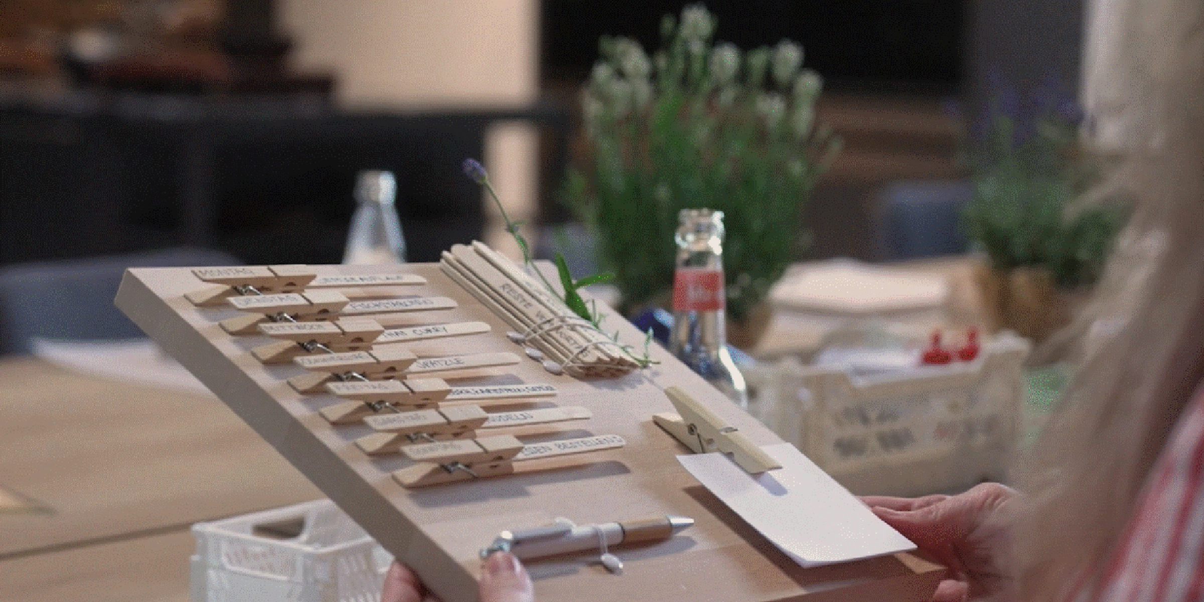 Une personne tient du matériel de bricolage sur une table dans une cuisine moderne de Nolte Kitchen.