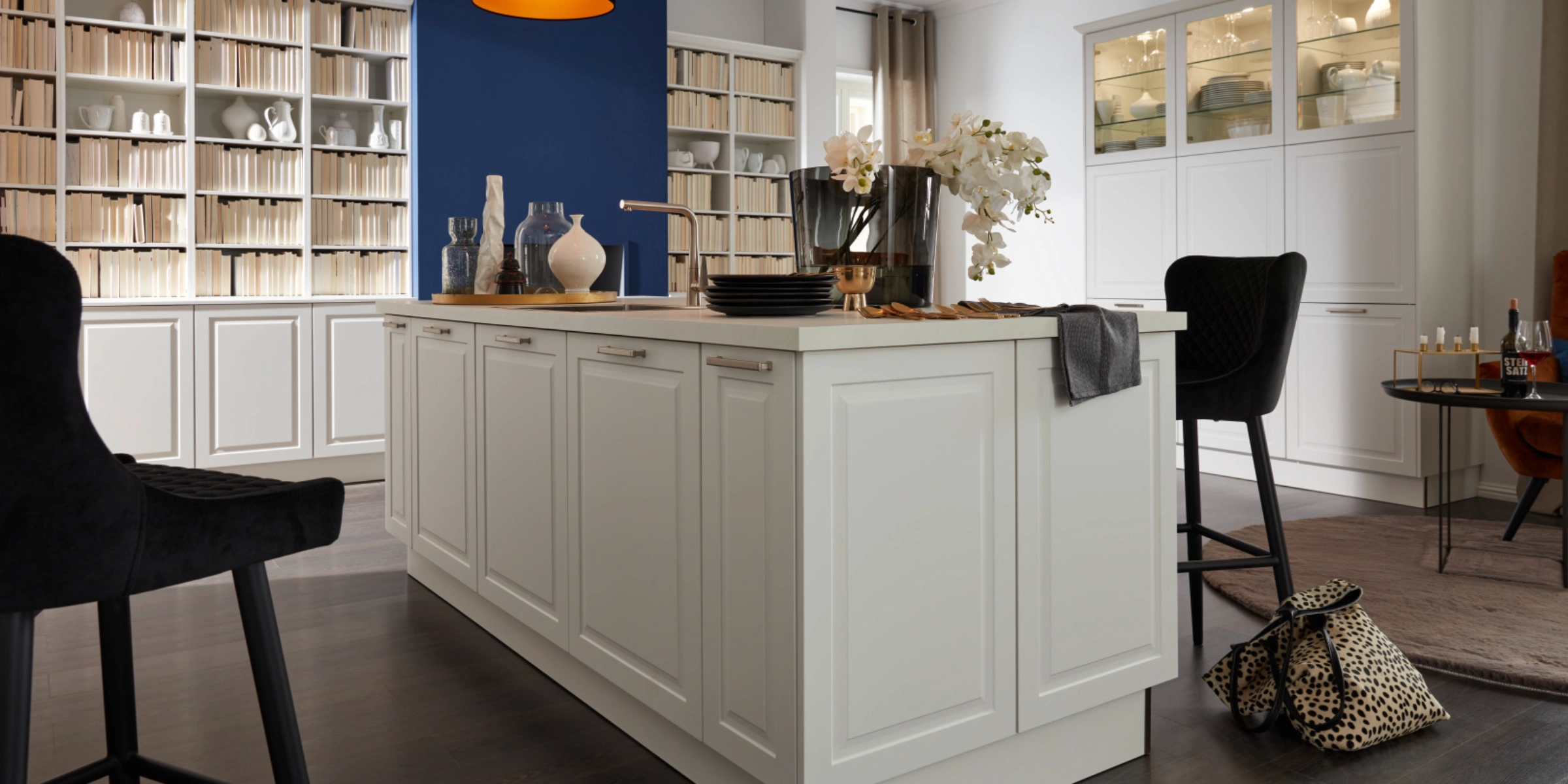 Cuisine moderne avec îlot blanc et mur bleu en arrière-plan, Nolte Kitchen.