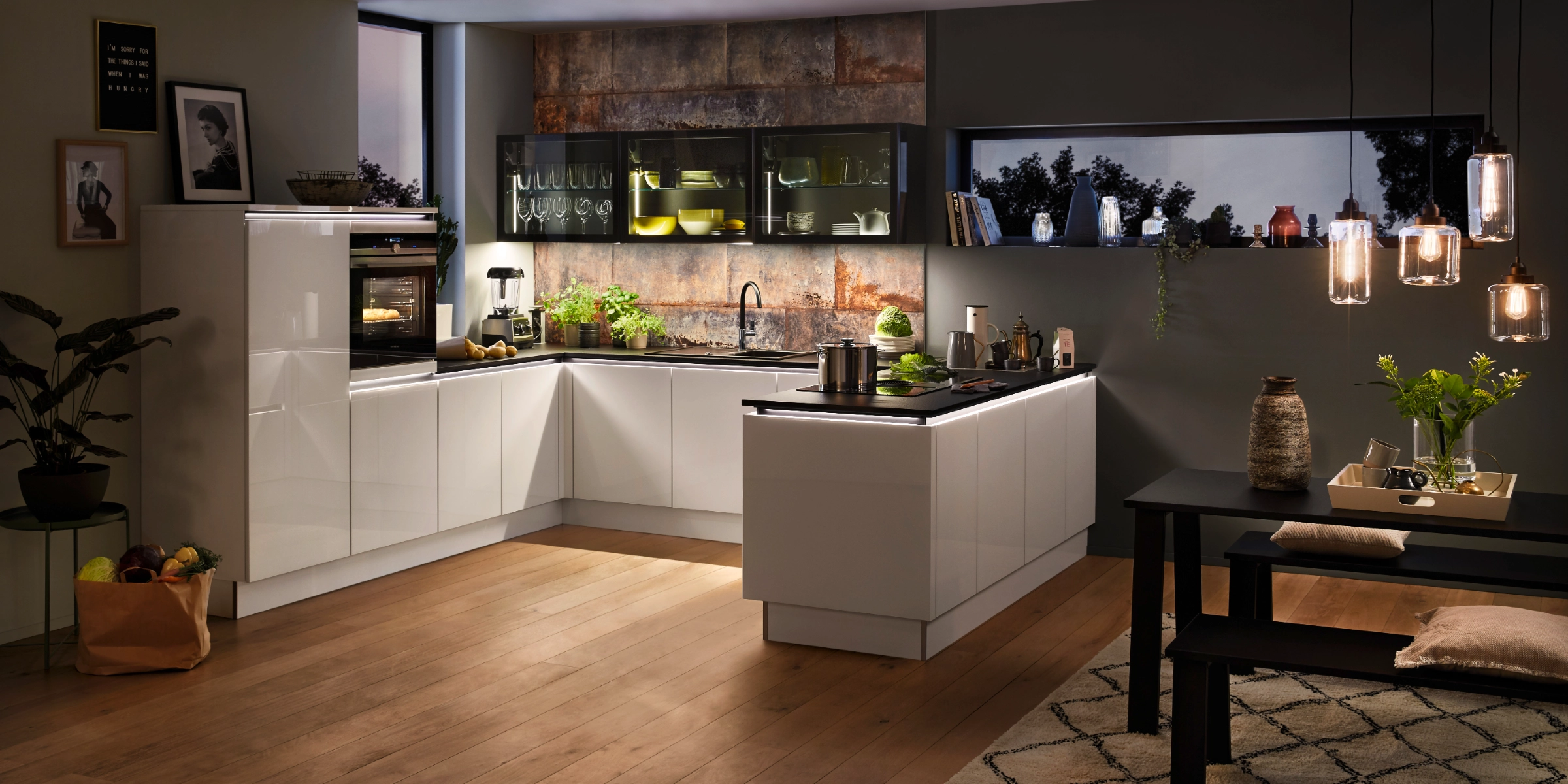 Cuisine moderne et élégante avec armoires blanches et sol en bois, conçue par Nolte Kitchen.