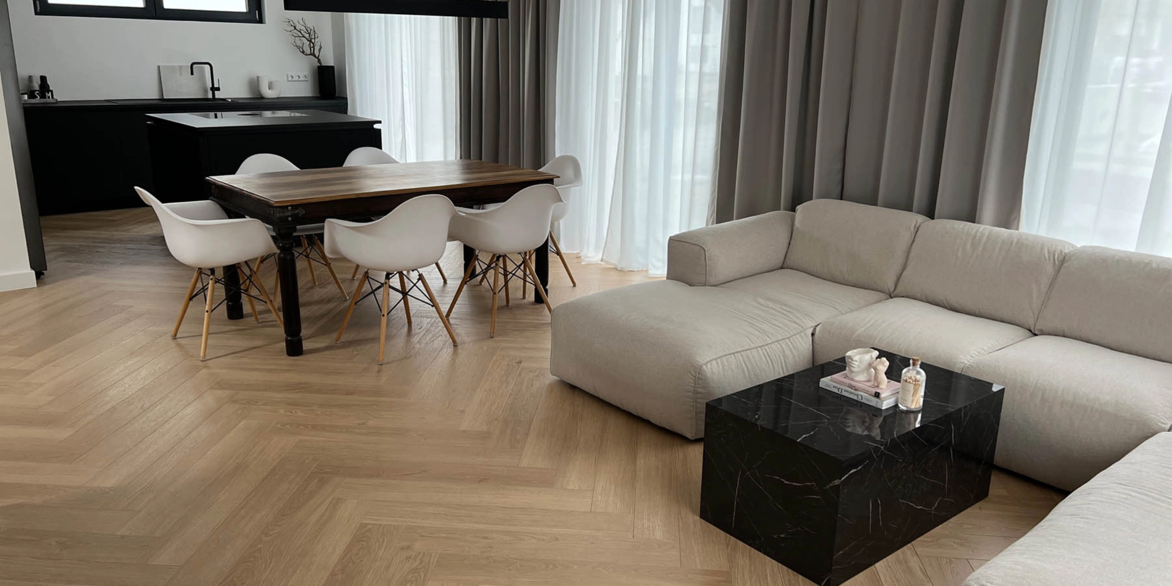Un moderno soggiorno con mobili Nolte Living e una cucina sullo sfondo.