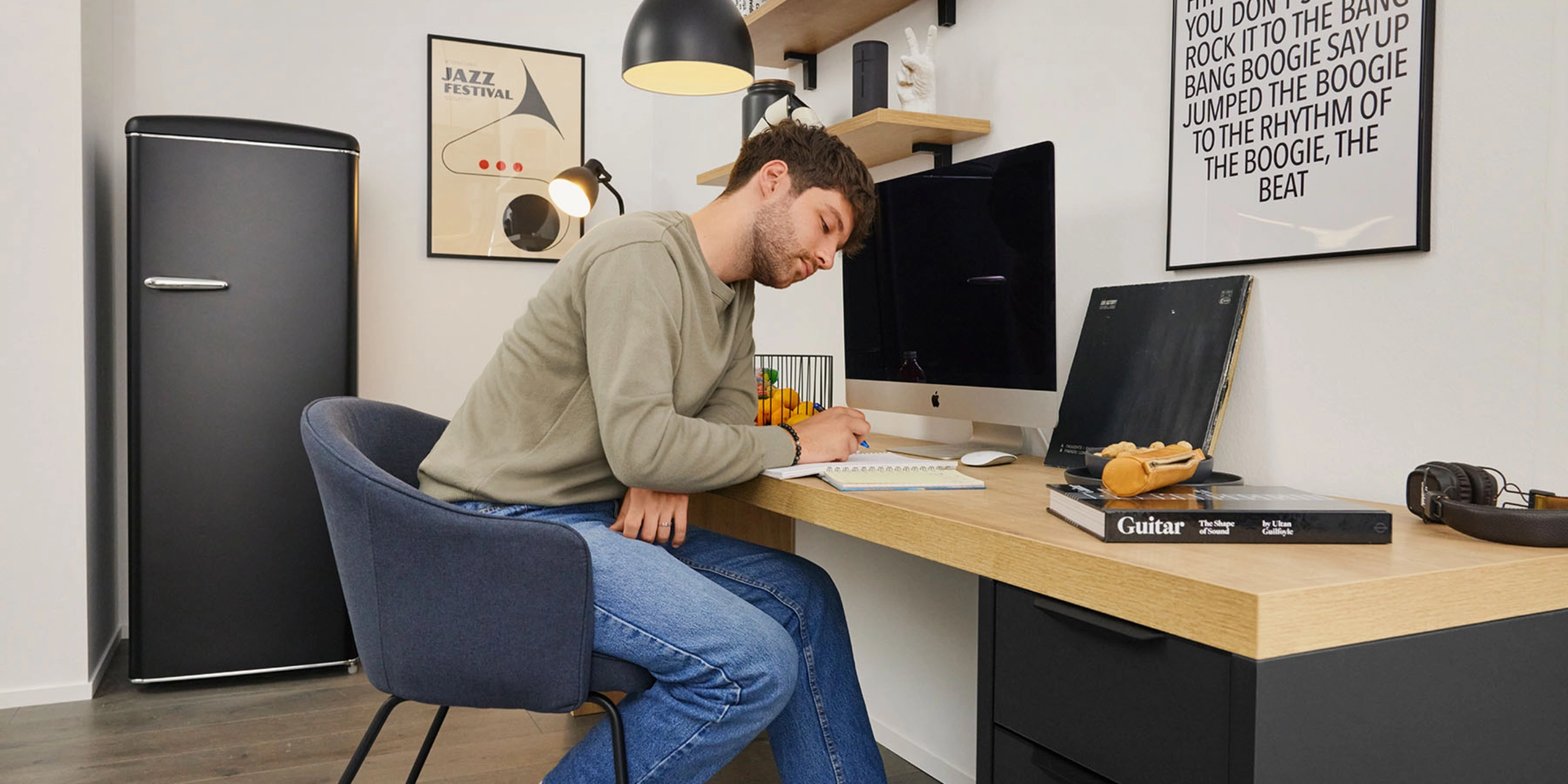 A man sits at a desk in a modern office featuring Nolte Living furniture.
