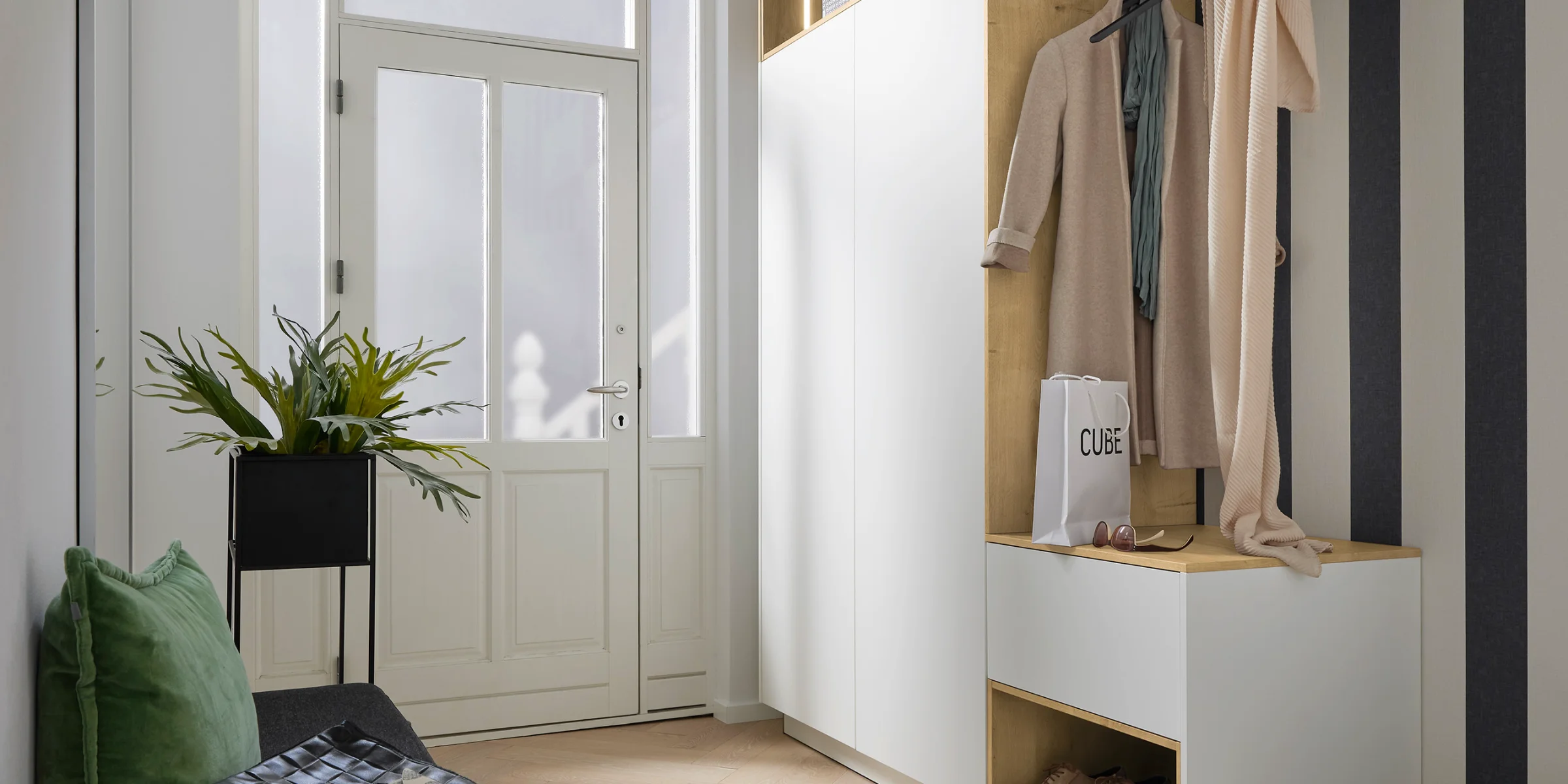 Ein stilvoll eingerichteter Eingangsbereich mit Garderobe, Sitzbank und Dekoration, passend für Nolte Living.