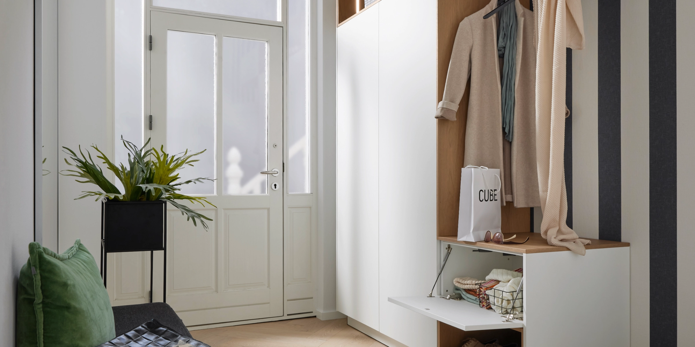 Un hall d'entrée élégant avec penderie, banc et décoration, idéal pour Nolte Living.