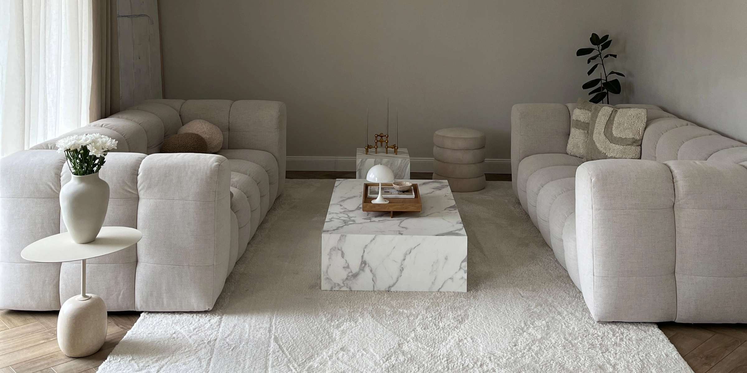 Un salon moderne avec deux canapés et une table en marbre, assortis à Nolte Living.