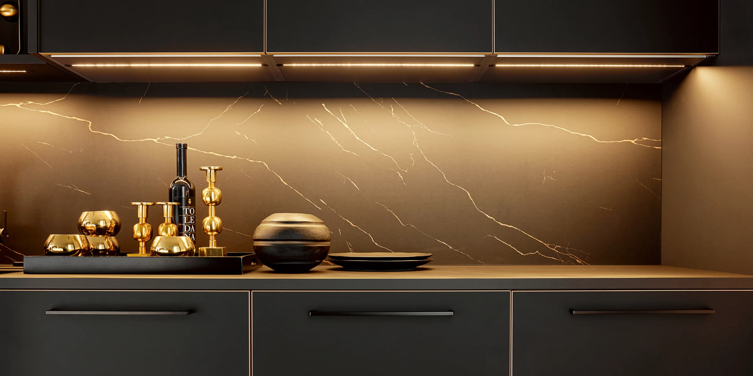 Eine moderne Küche mit dunklen Schränken und stilvoller Beleuchtung. Nolte Küchen.