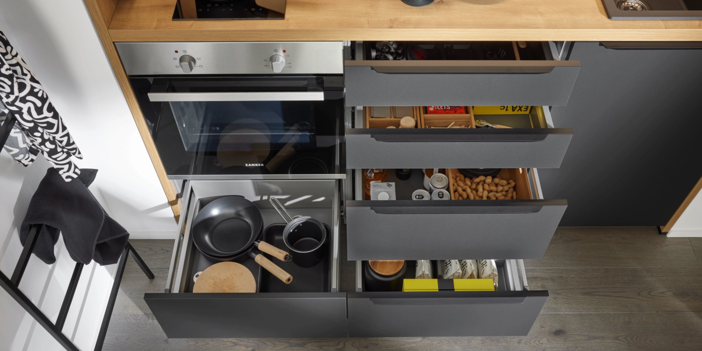 Une cuisine moderne avec tiroirs ouverts et ustensiles de cuisine, conçue par Nolte Kitchen.