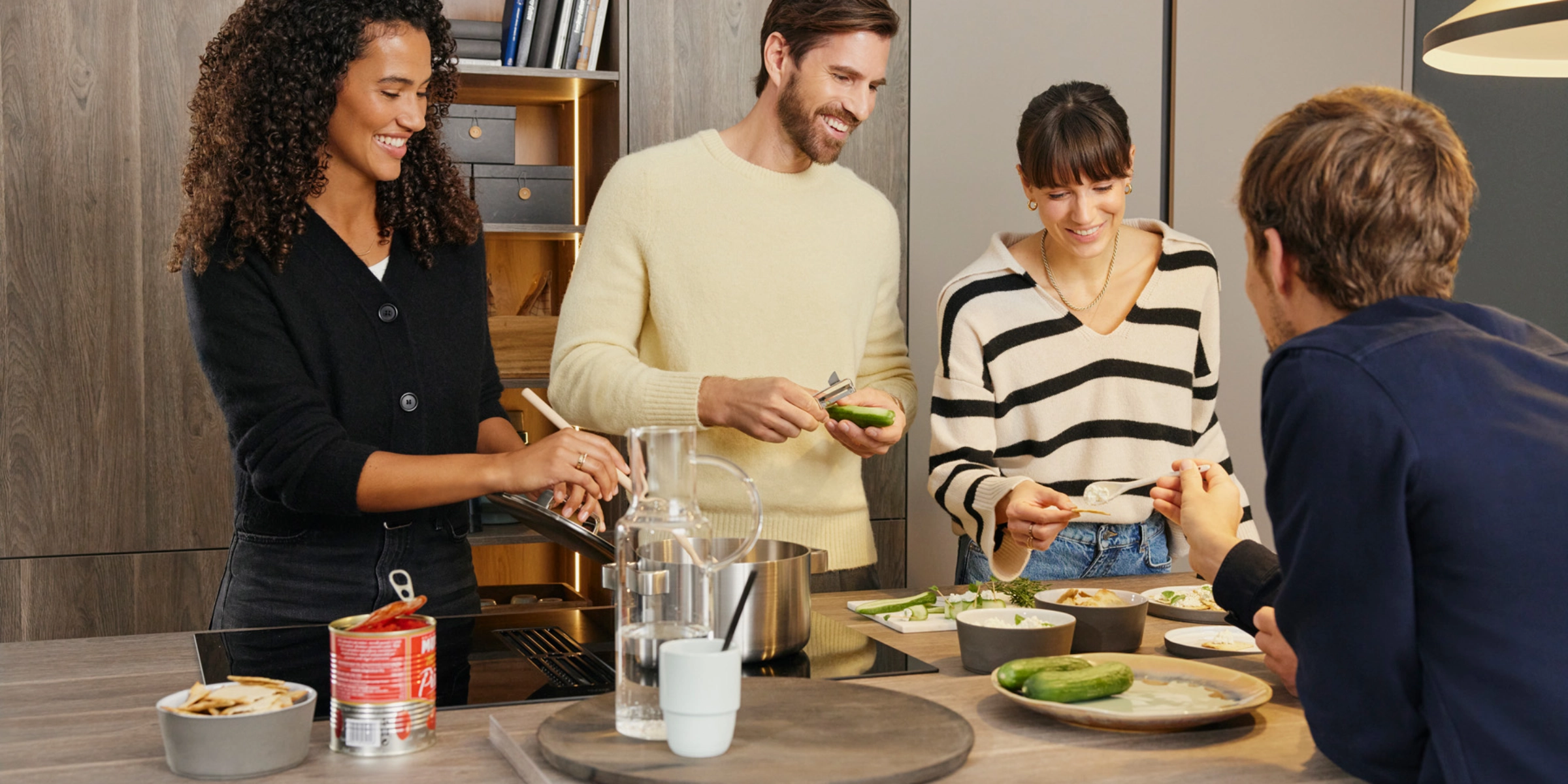 Un groupe de personnes cuisine ensemble dans une cuisine moderne Nolte.