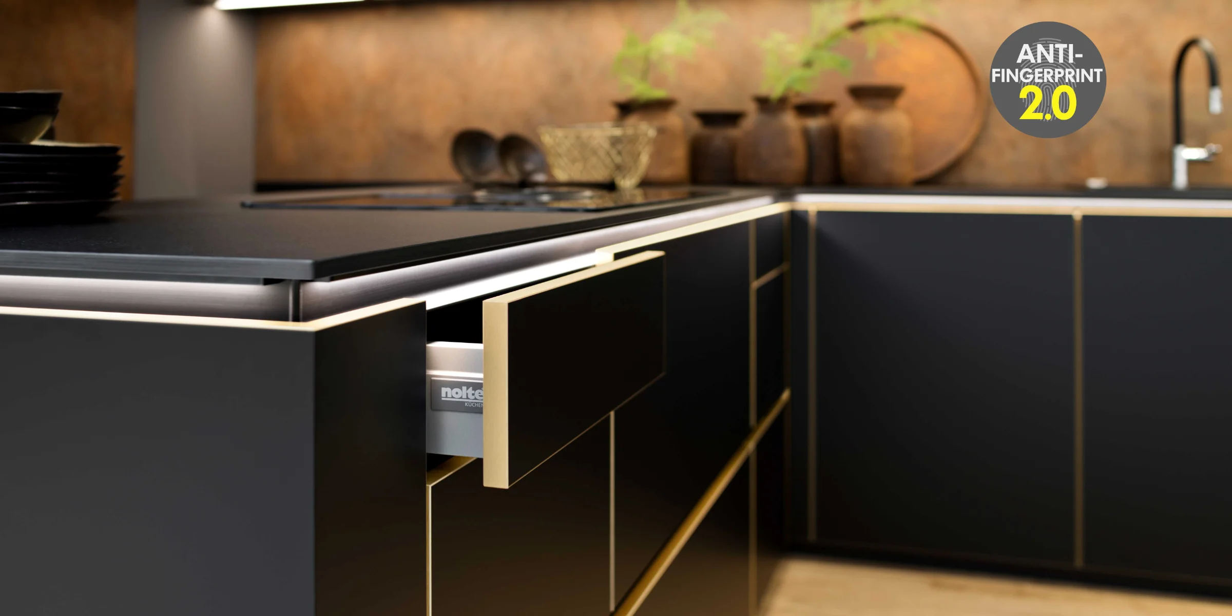 Cucina moderna con armadi neri e accenti dorati, design di Nolte Kitchen.