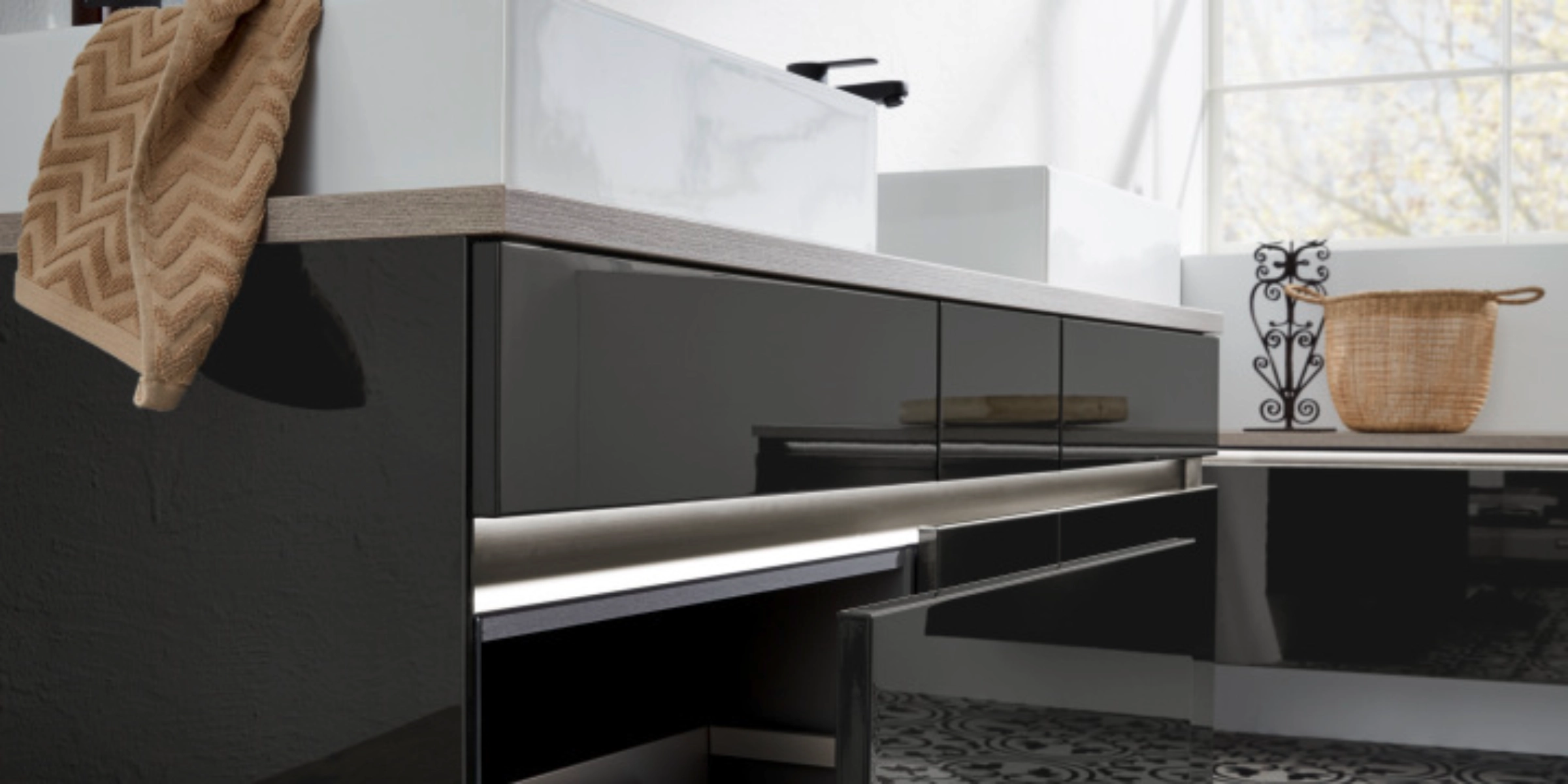 Un baño moderno con armarios negros y dos lavabos de Nolte SPA.