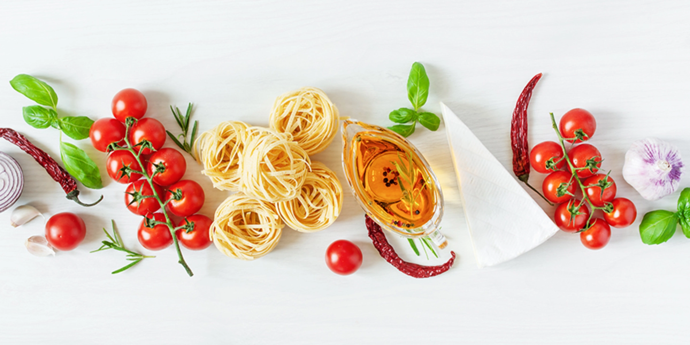 Deux personnes préparent ensemble un repas. Sur un plan de travail de cuisine, des légumes sont coupés et une salade est mélangée.