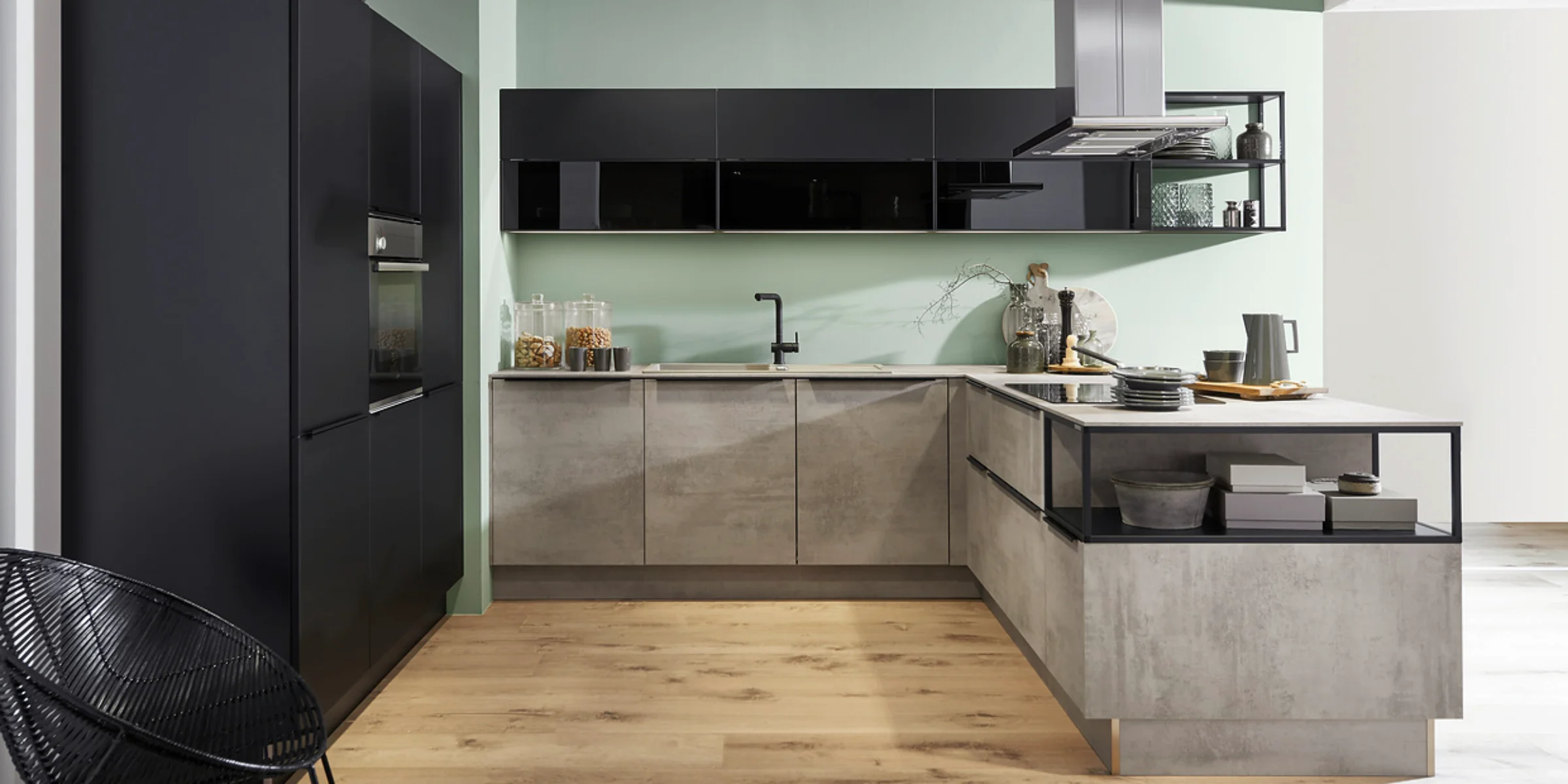 Moderne schwarze Küche in Betonoptik mit schlichten schwarzen Griffleisten und offenen Regalen von Nolte Küchen – elegantes Küchendesign mit klarer Linienführung.