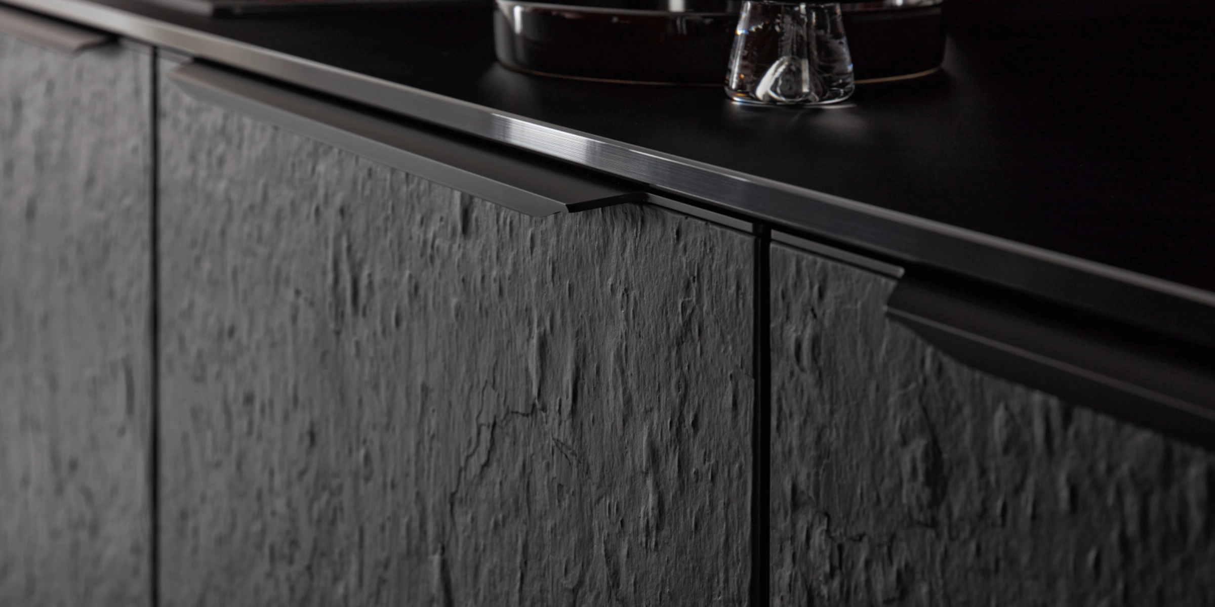 Une cuisine moderne avec façades sombres texturées et détails élégants de Nolte Kitchen.