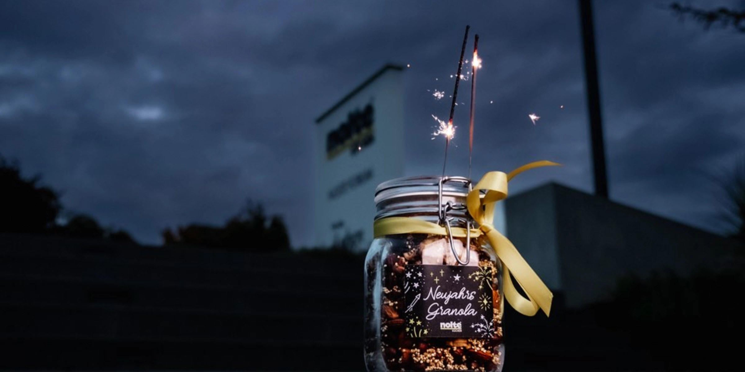 Szklanka z zimnymi ogniami i żółtą wstążką przed znakiem nocą.