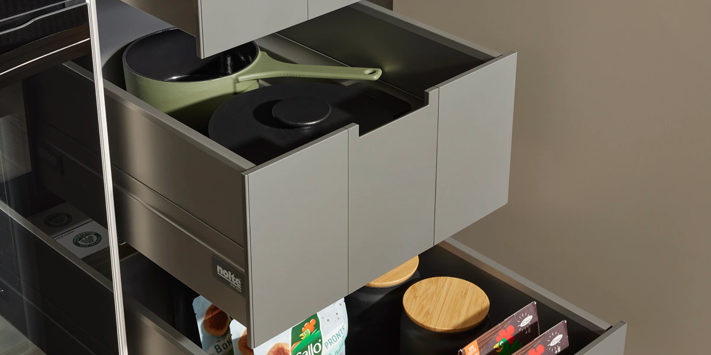 Cajones de cocina abiertos con contenido organizado en una cocina moderna de Nolte Cocina.