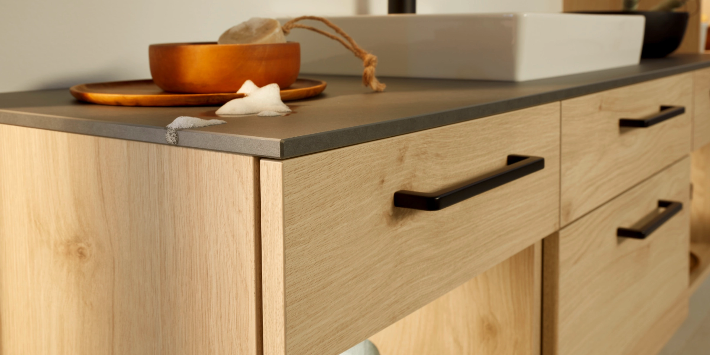 Een modern badkamer met houten kasten en wastafel, gepresenteerd door Nolte SPA.