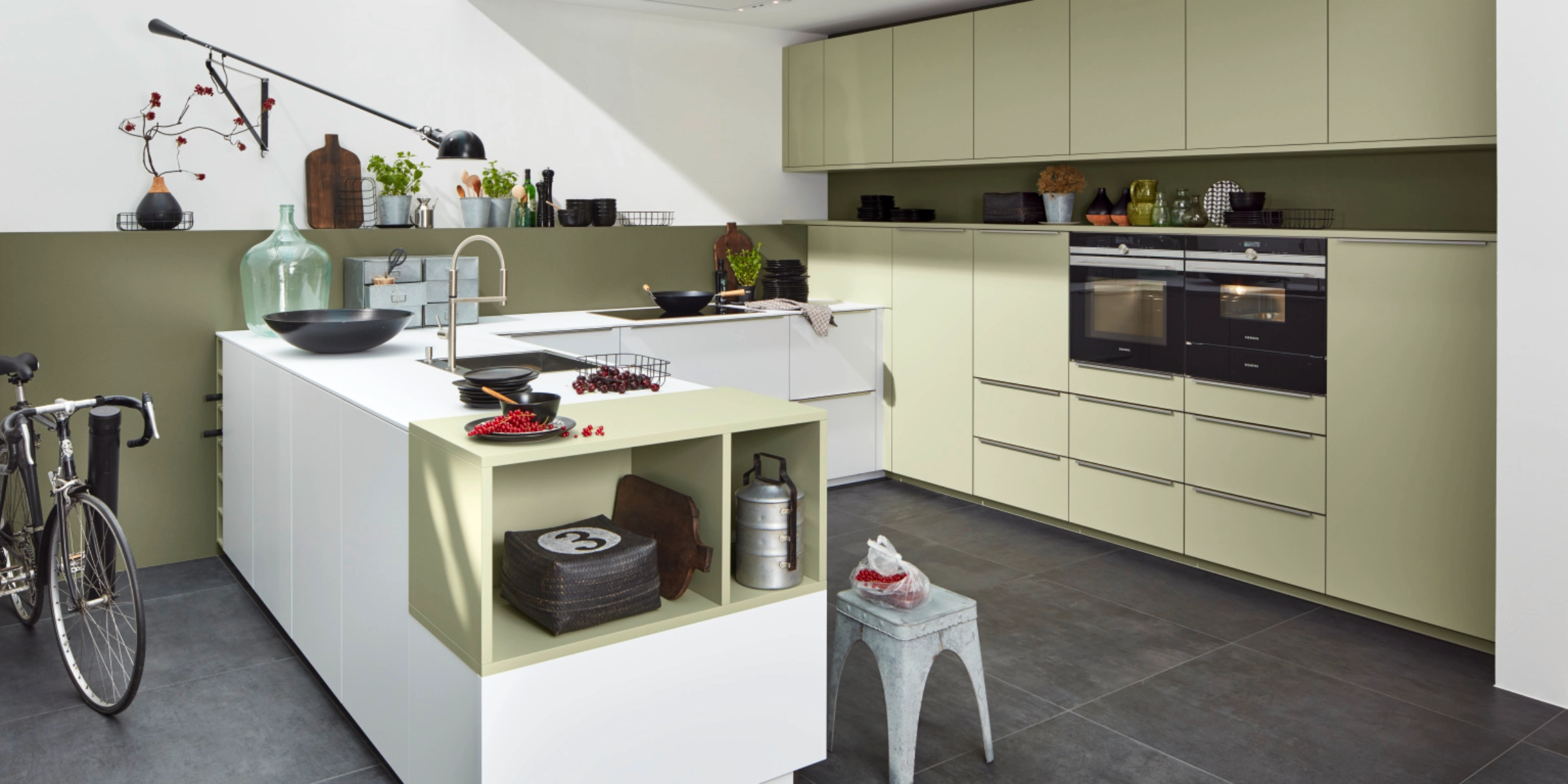 Cuisine moderne avec îlot et armoires claires, conçue par Nolte Kitchen.