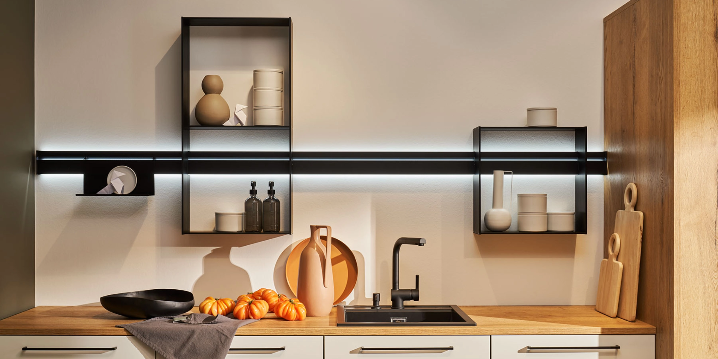 Een moderne keuken met houten werkblad en stijlvolle planken, ontworpen door Nolte Kitchen.