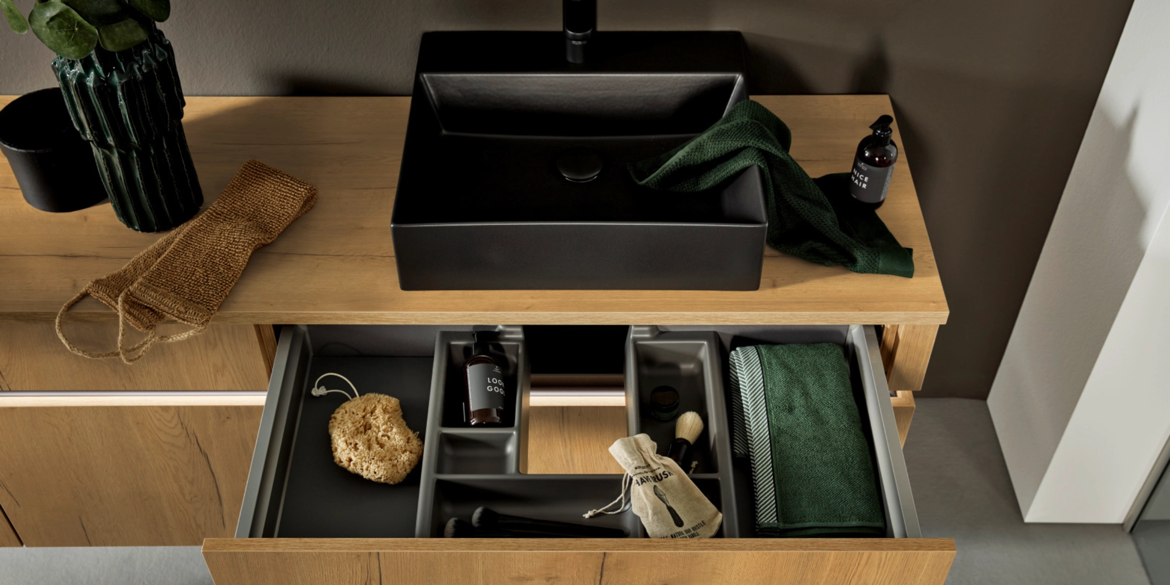 Une salle de bain moderne avec armoire en bois et lavabos noirs, Nolte SPA.