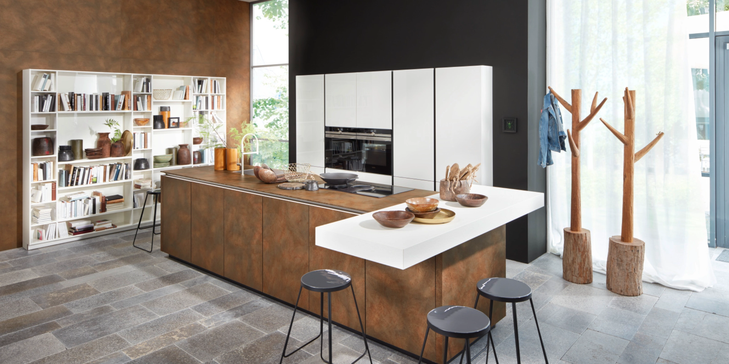 Modern Nolte kitchen with kitchen island in FERRO Corten steel and tall cabinets in NOVA LACK White High Gloss – stylish combination of industrial look and noble shine in an open living concept.