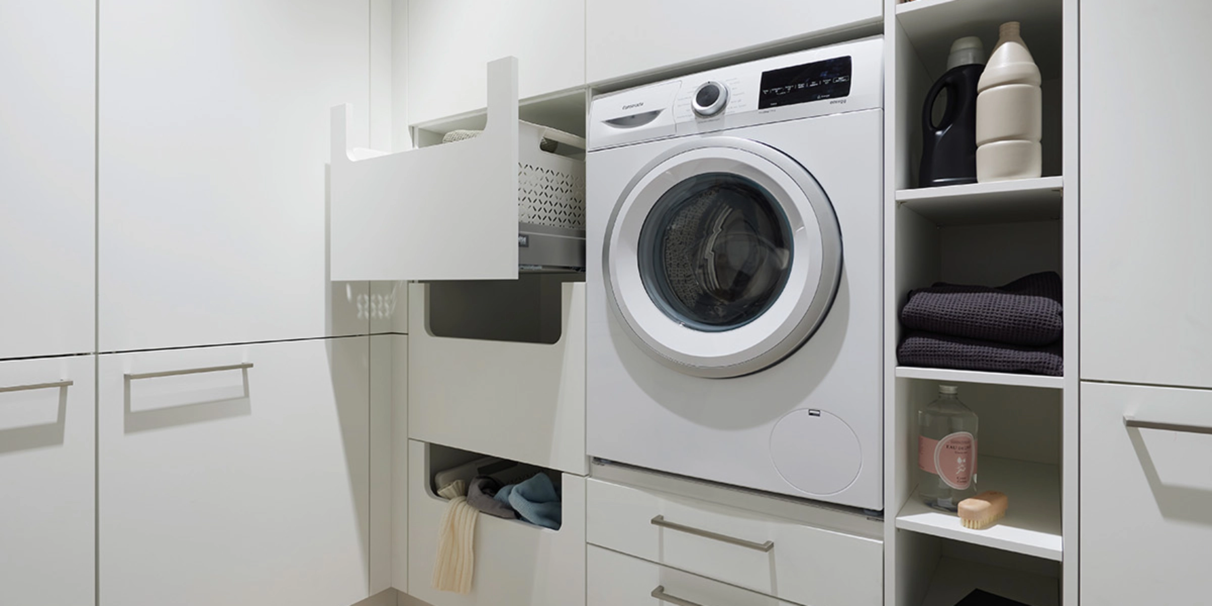 Buanderie moderne avec machine à laver et rangement, conçue par Nolte Utility Rooms.
