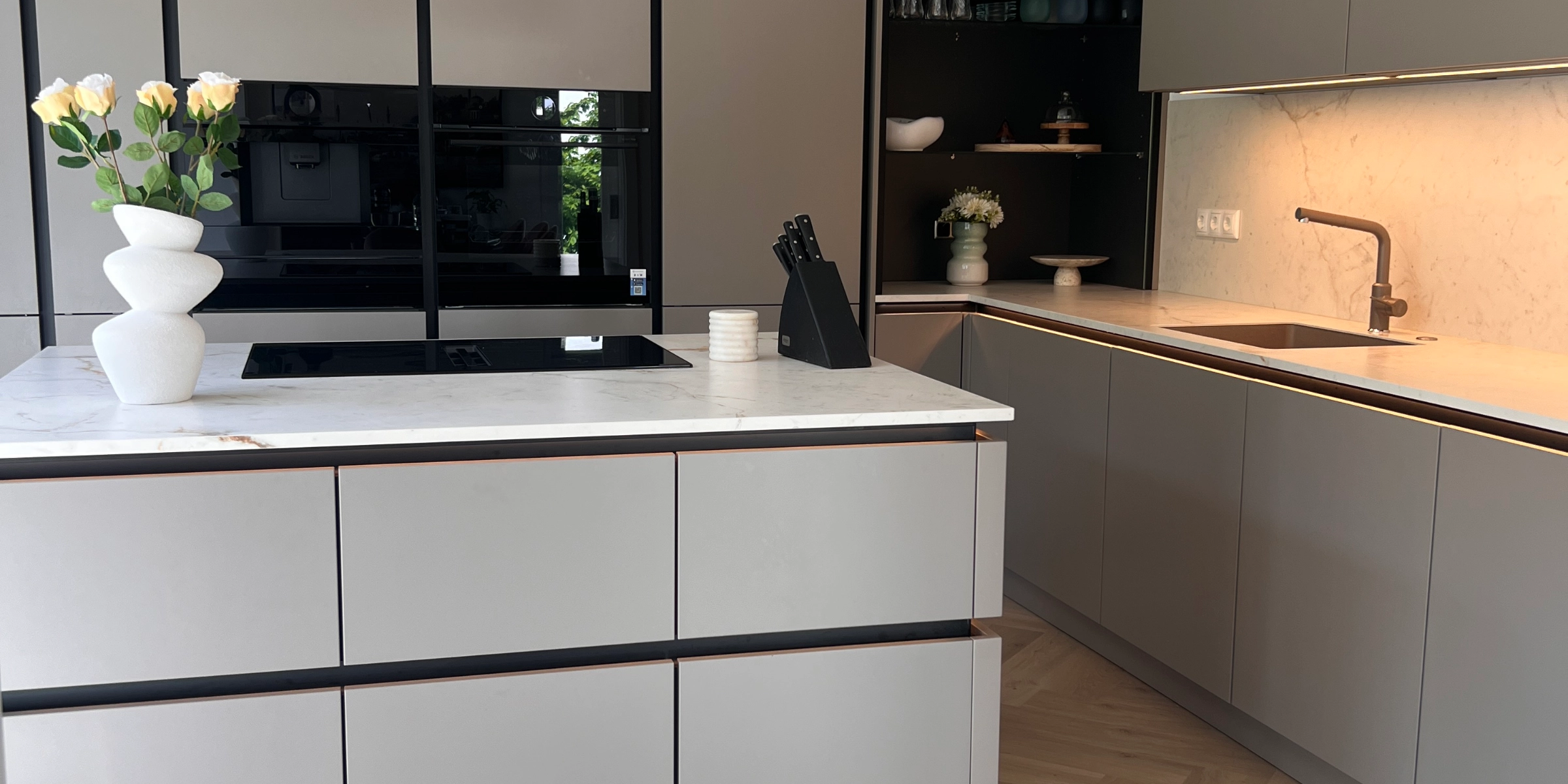 Cuisine moderne avec armoires grises et îlot central. Nolte Kitchen.