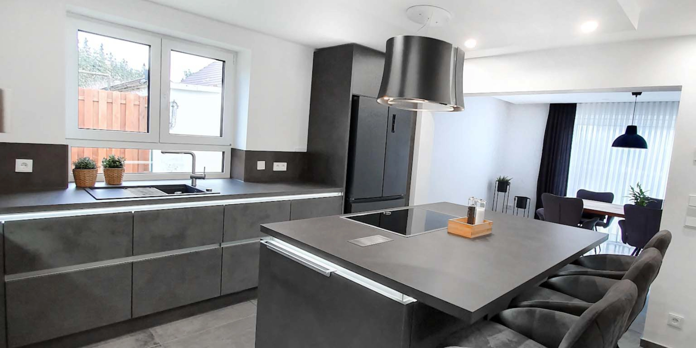 Cuisine moderne avec îlot gris et tabourets de bar dans un espace ouvert, Nolte Kitchen.