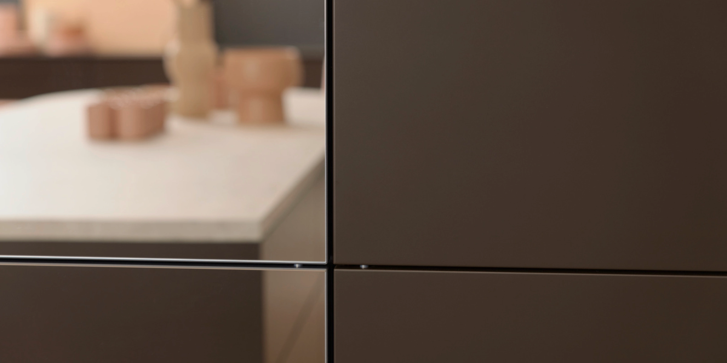 Une cuisine moderne avec des armoires sombres et un plan de travail clair, Nolte Kitchen.