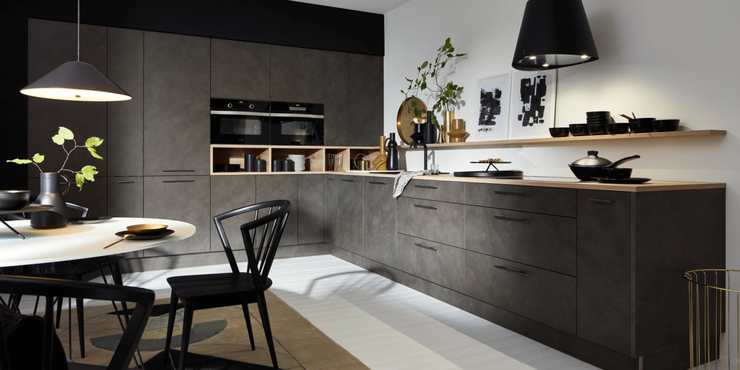 Cuisine moderne avec armoires sombres et éclairage élégant, conçue par Nolte Kitchen.