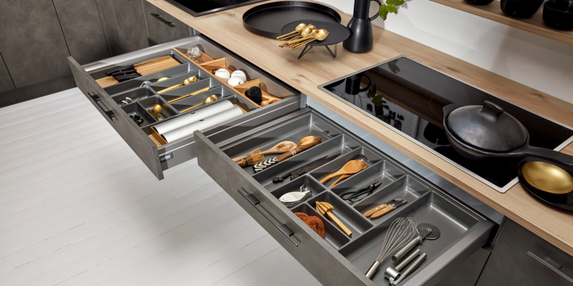 Une cuisine moderne avec tiroirs ouverts montrant couverts et ustensiles. Nolte Kitchen.