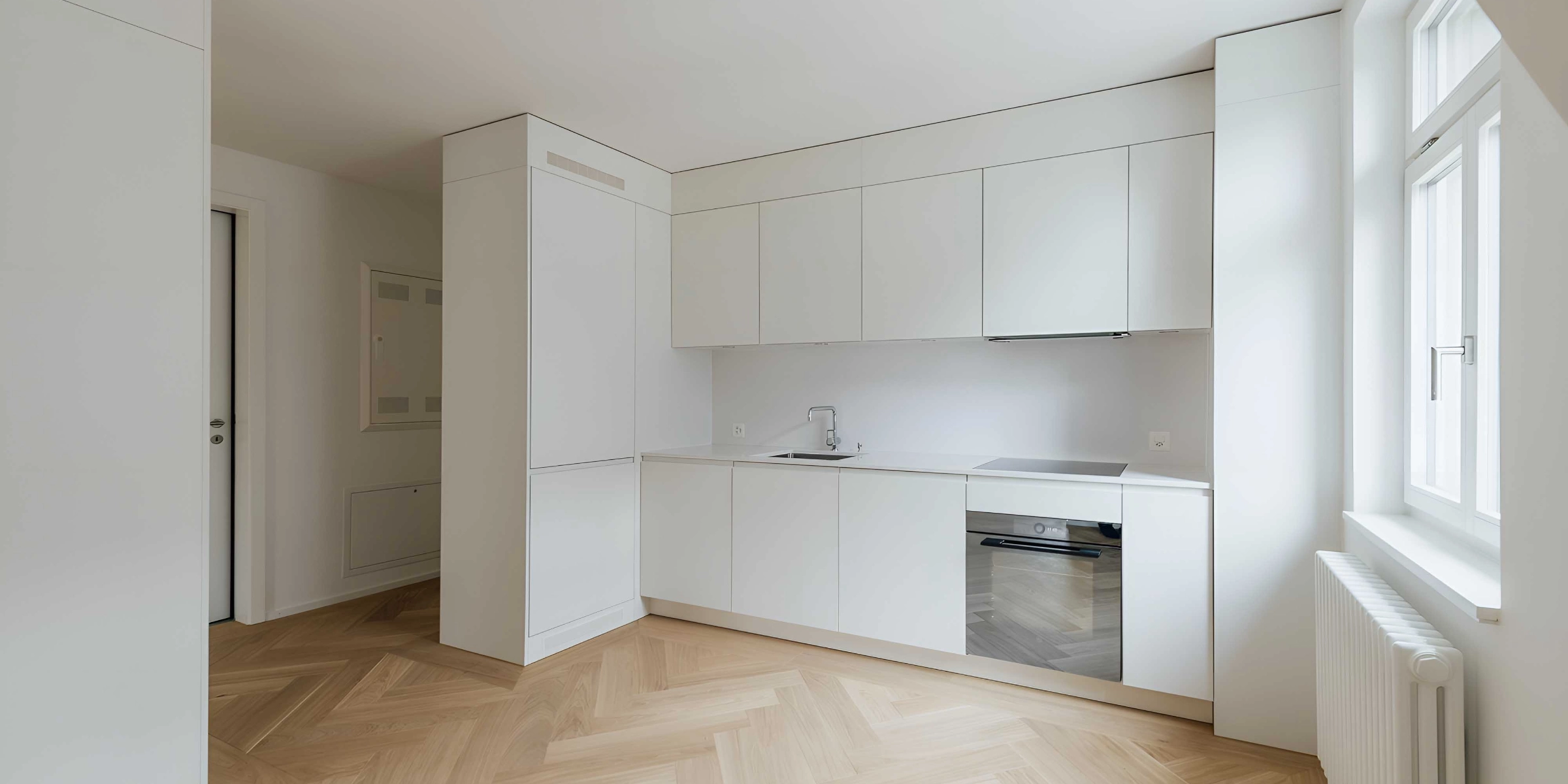 Eine moderne, minimalistische Küche mit weißen Schränken und Holzfußboden von Nolte Küchen.