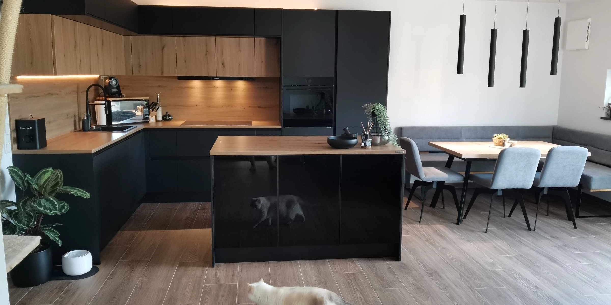 Cuisine moderne avec éléments bois et noirs, îlot et table; Nolte Kitchen.