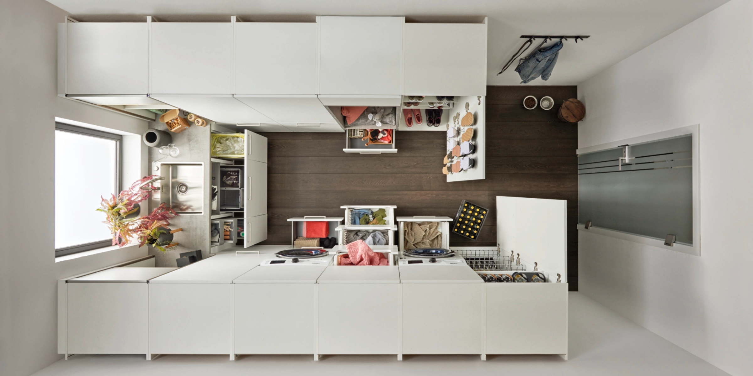 Salle d'économie domestique de Nolte avec le programme de façades FEEL en Blanc Softmatt, soigneusement planifiée pour une utilisation maximale de l'espace de rangement, des processus ergonomiques et une organisation optimale – y compris la machine à laver, l'évier et un système de rangement intelligent.