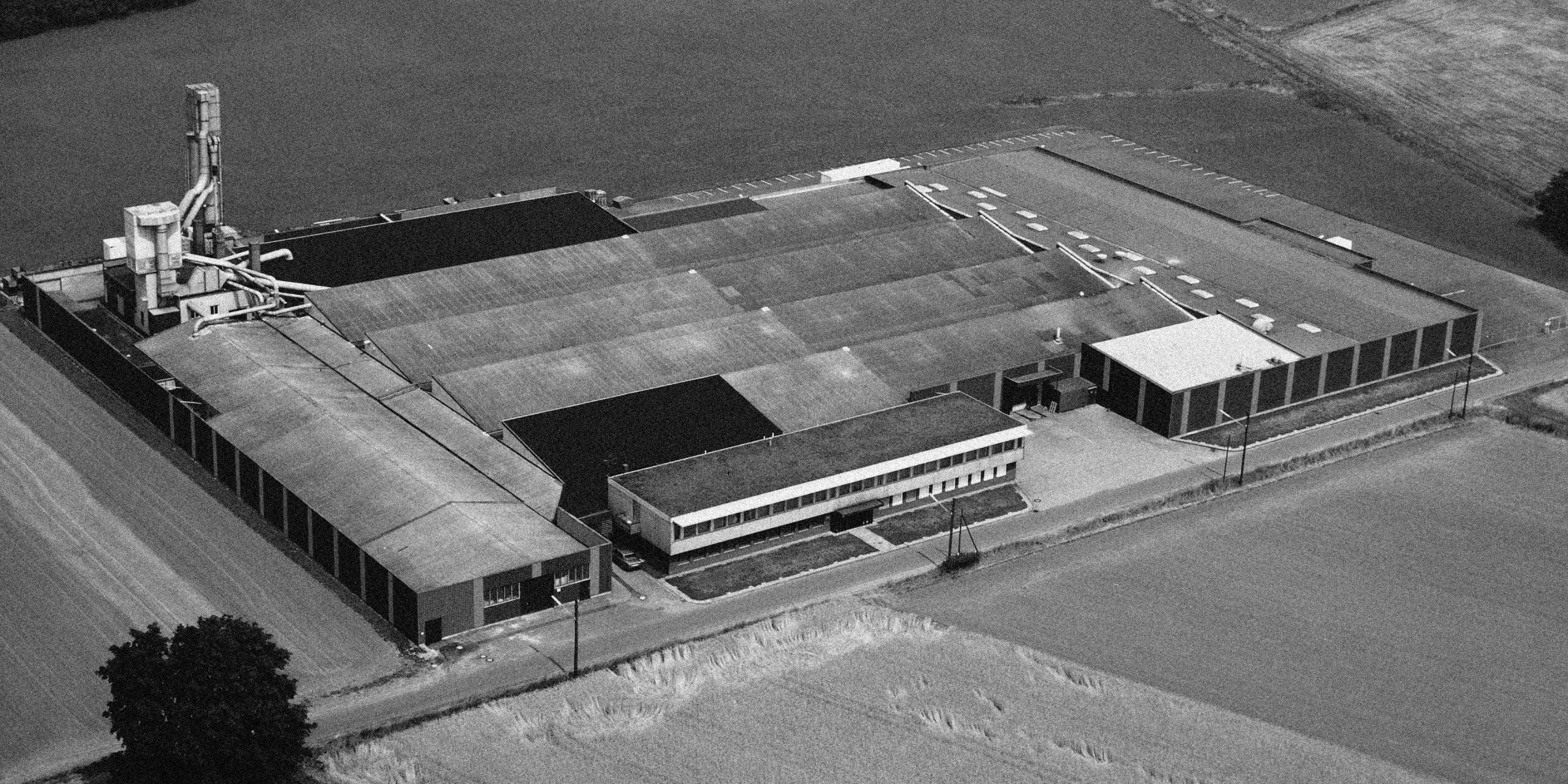 Une grande usine entourée de champs où sont fabriqués des produits Nolte.