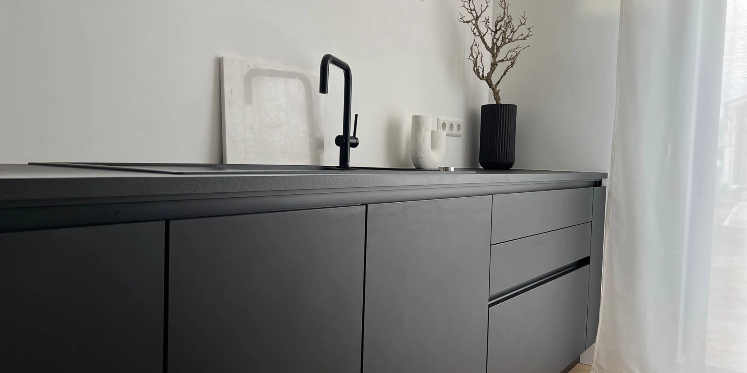 Cucina moderna con superficie nera e decorazioni, Nolte Kitchen.