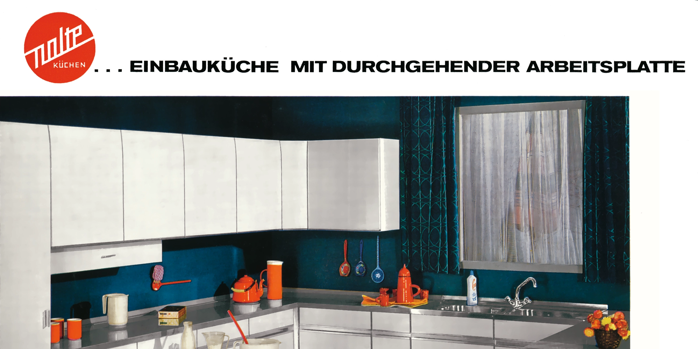 Cuisine moderne avec déco claire et corbeille de fruits, présentée par Nolte Kitchen.