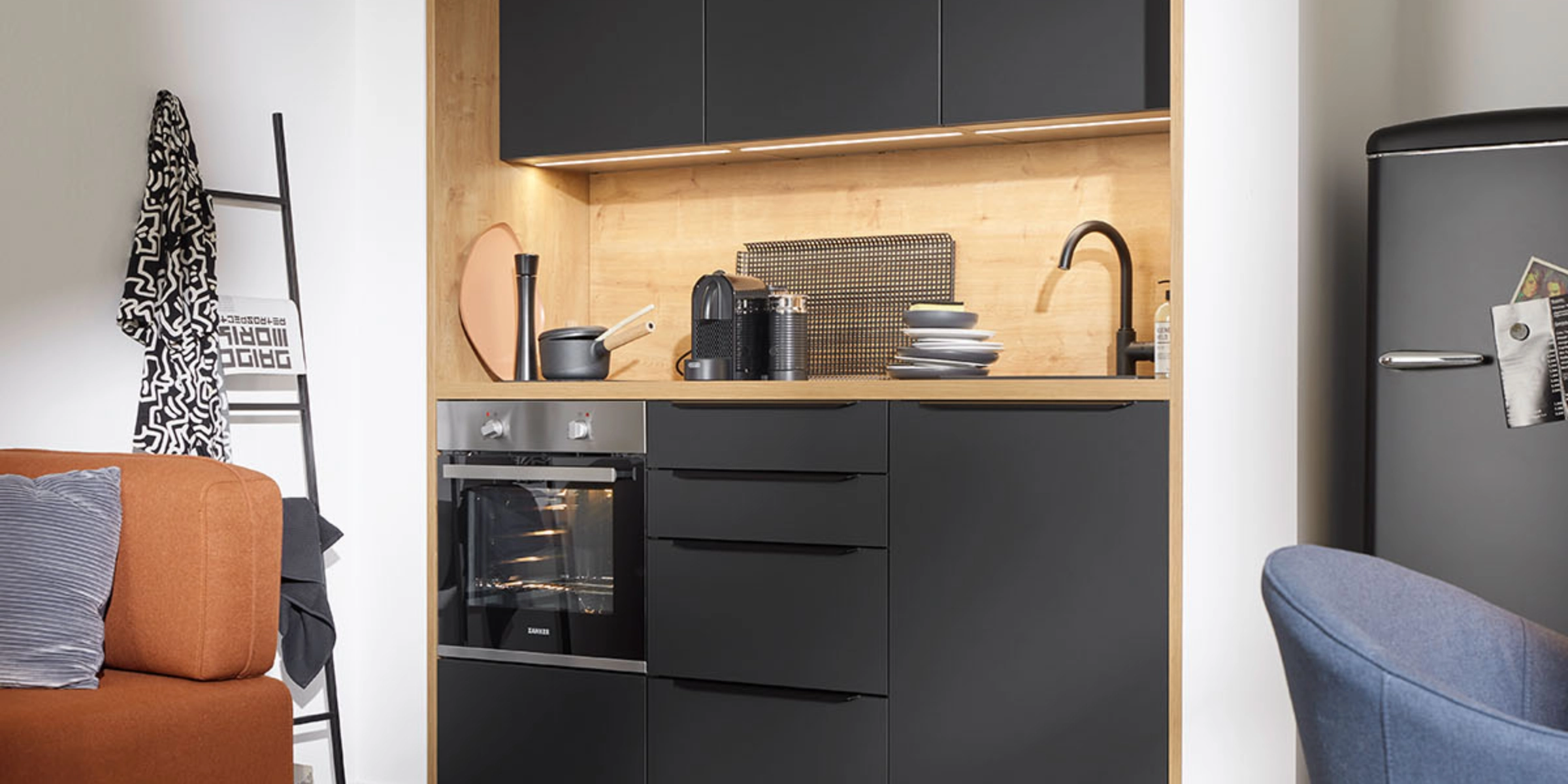 A modern kitchen with black cabinets and wood accents by Nolte Kitchen.