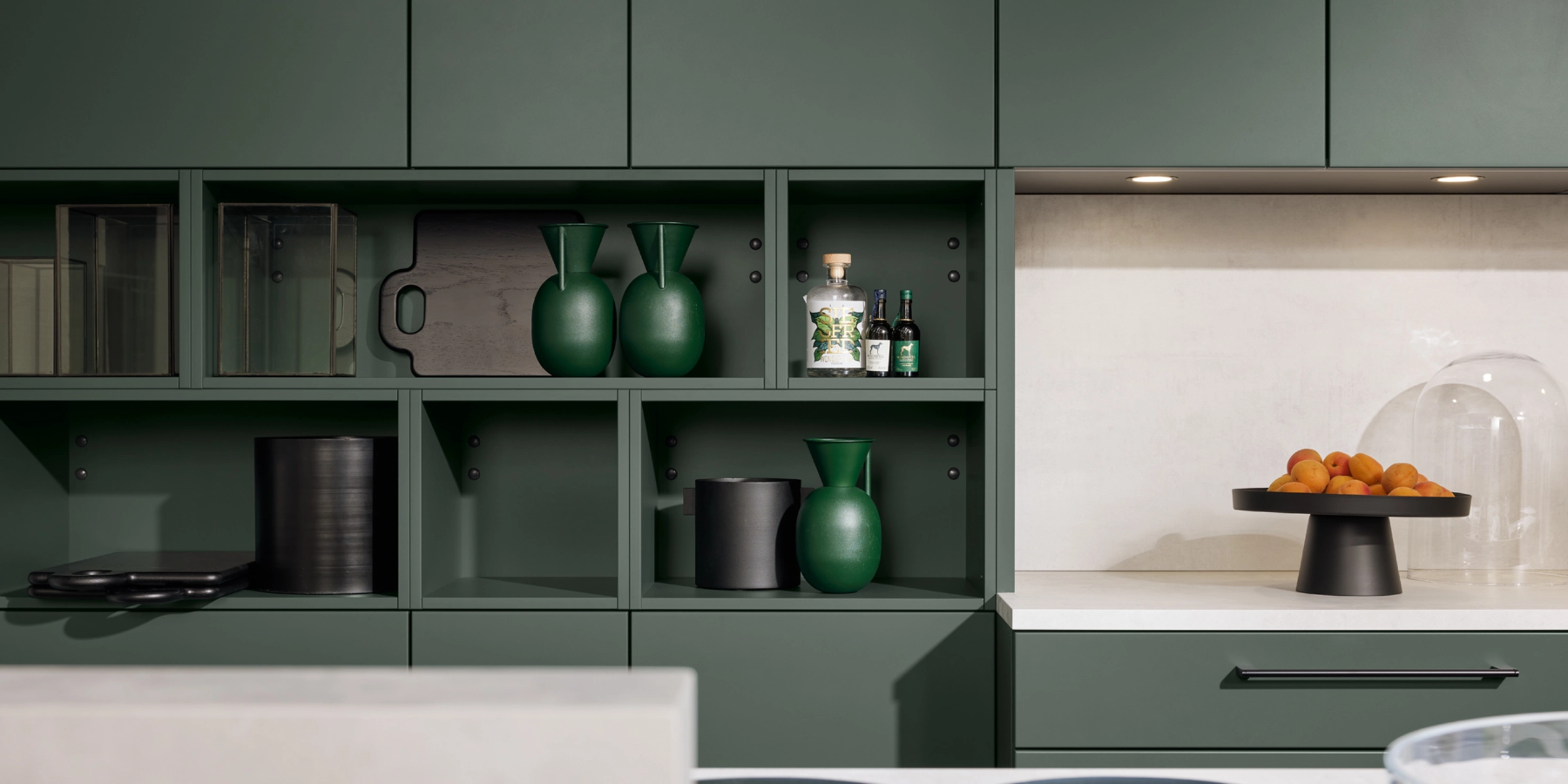 Une cuisine moderne avec des armoires vertes et déco, conçue par Nolte Kitchen.