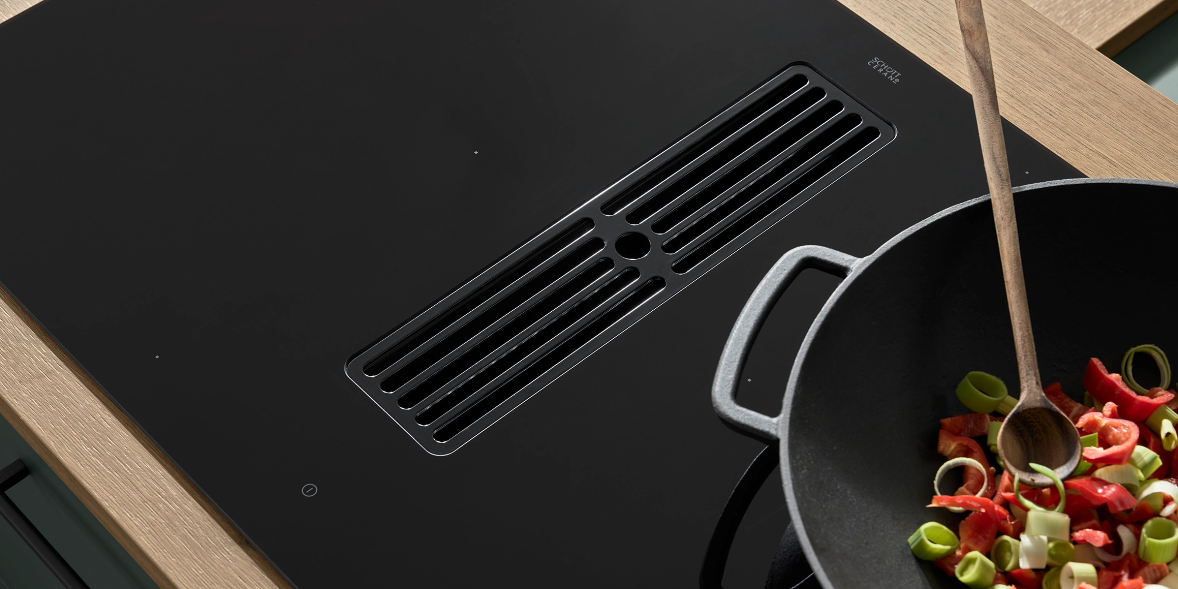 Une hotte de cuisine moderne avec wok et légumes dans une cuisine Nolte.
