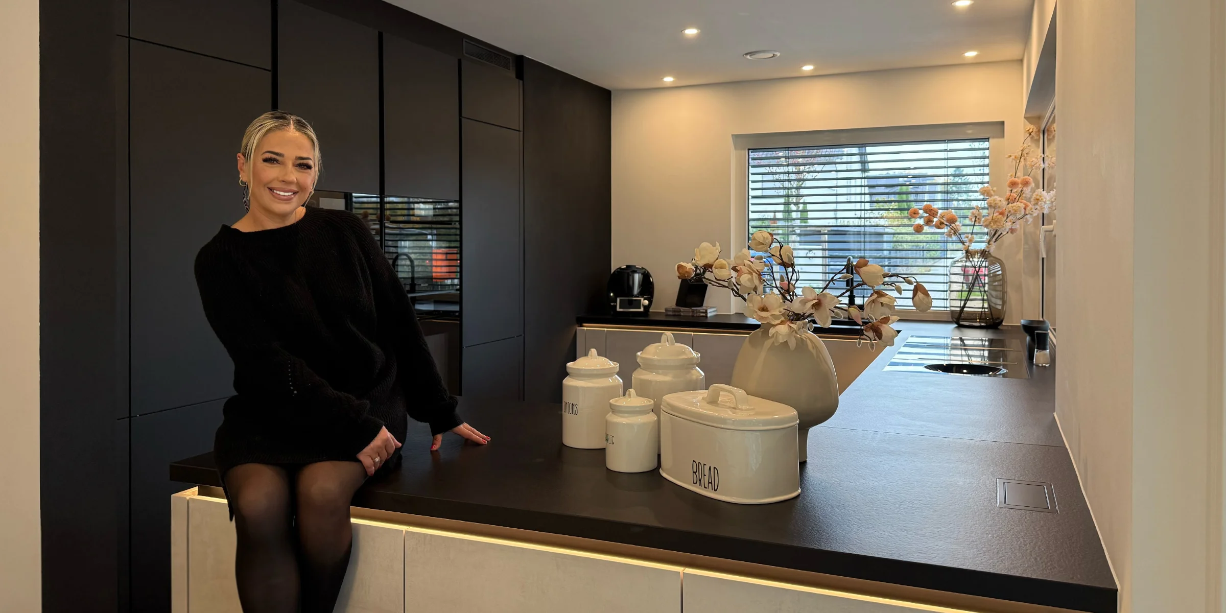 Eine moderne Küche mit dunklen Schränken und stilvollen Dekorationen. Nolte Küchen.