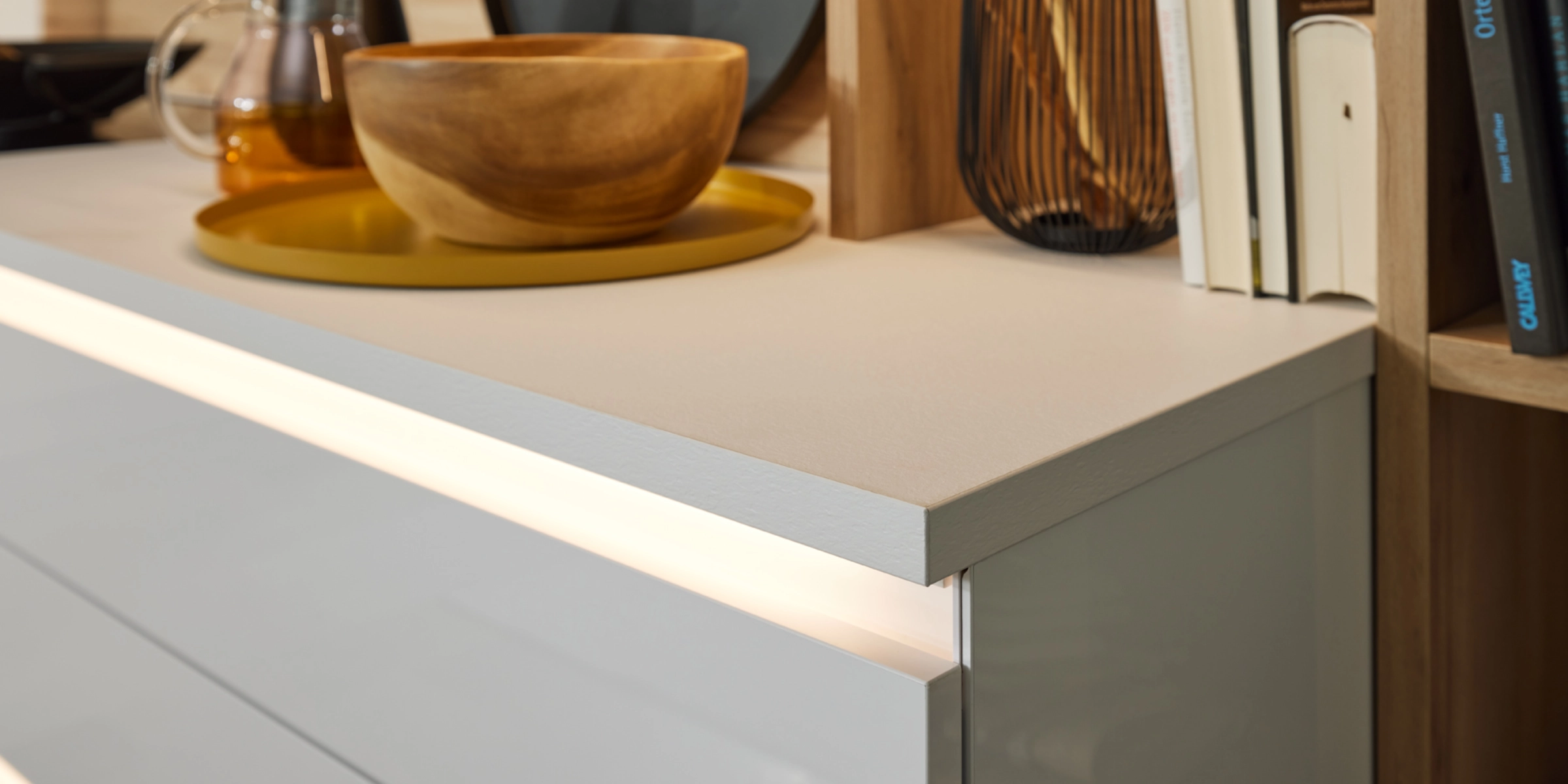 Un comptoir de cuisine moderne avec bol en bois et ustensiles de cuisine, Nolte Kitchen.